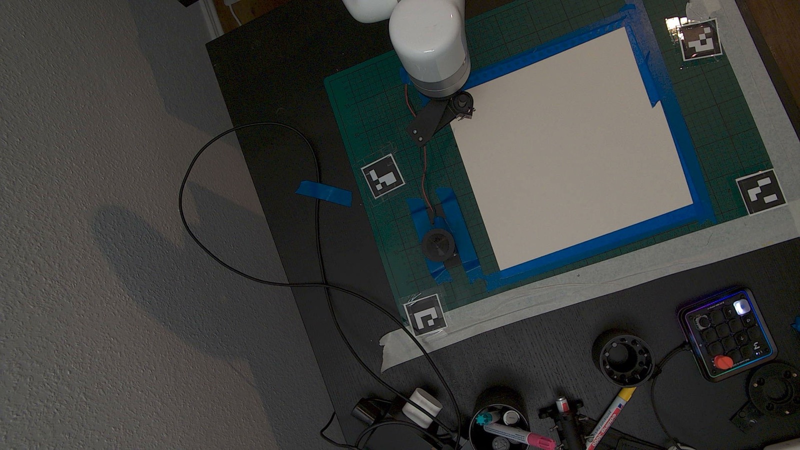 Overhead view of the xArm, paper workspace, markers, and operator controls
